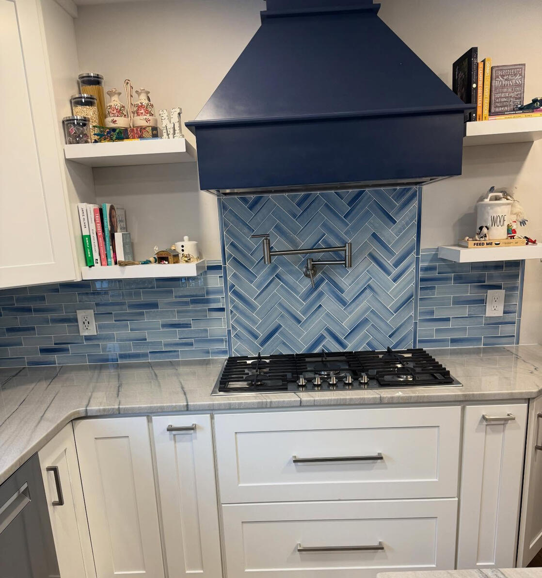 Finished blue tile backsplash with herringbone accent behind gas cooktop Finished blue tile backsplash with herringbone accent behind gas cooktop