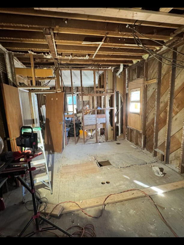 Bathroom remodel in progress with exposed wall and ceiling framing