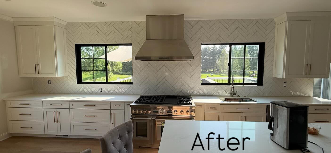 Kitchen after backsplash renovation with white herringbone tile and stainless range hood Kitchen after backsplash renovation with white herringbone tile and stainless range hood