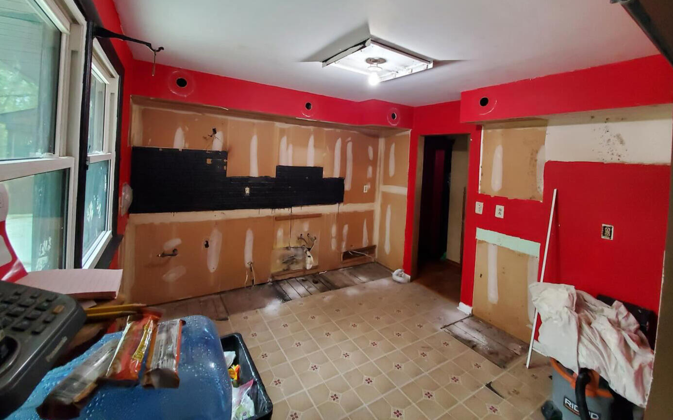 Kitchen renovation in progress with cabinets removed and walls being prepared