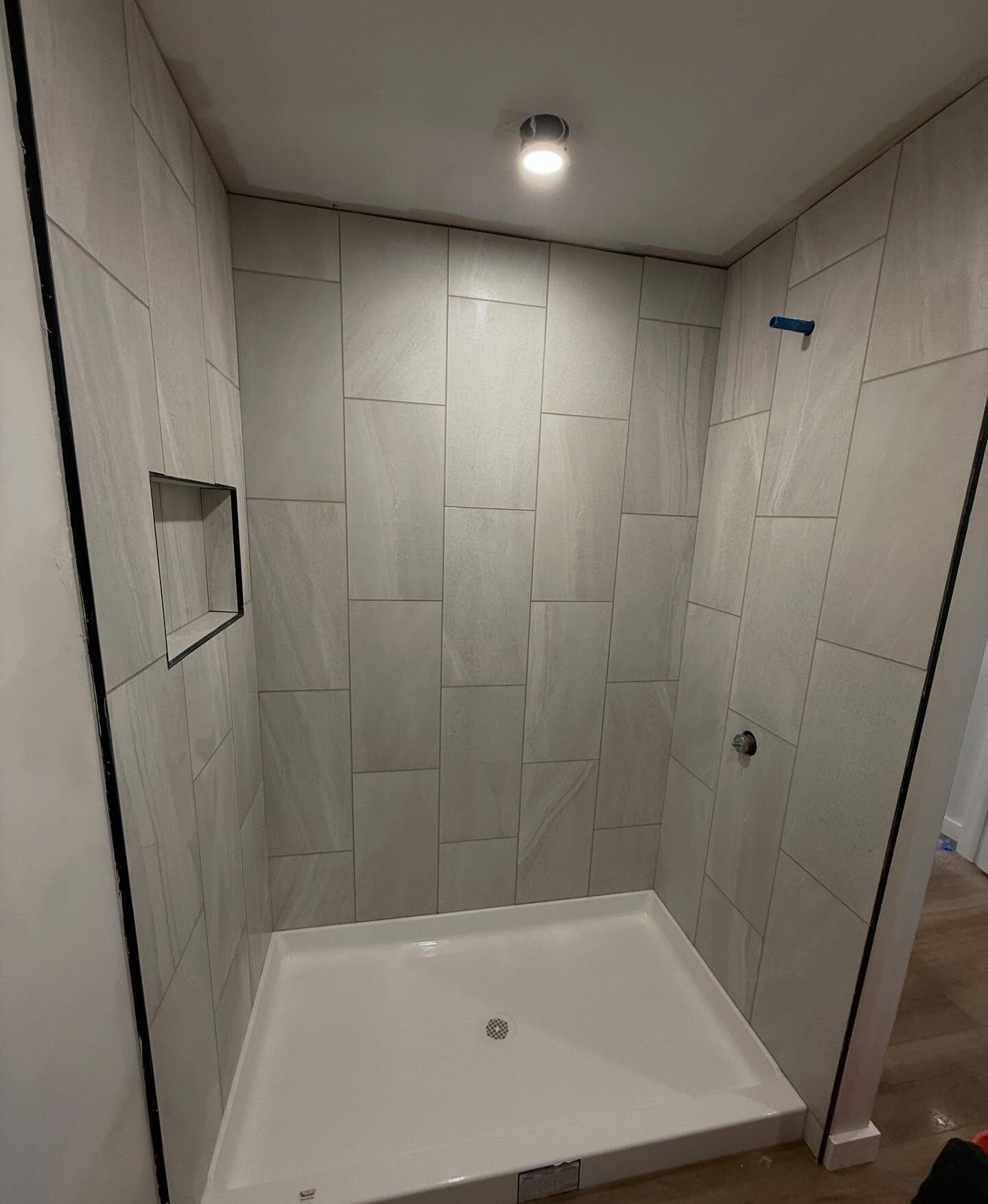 Finished gray tiled shower with glass enclosure and recessed niche Finished gray tiled shower with glass enclosure and recessed niche